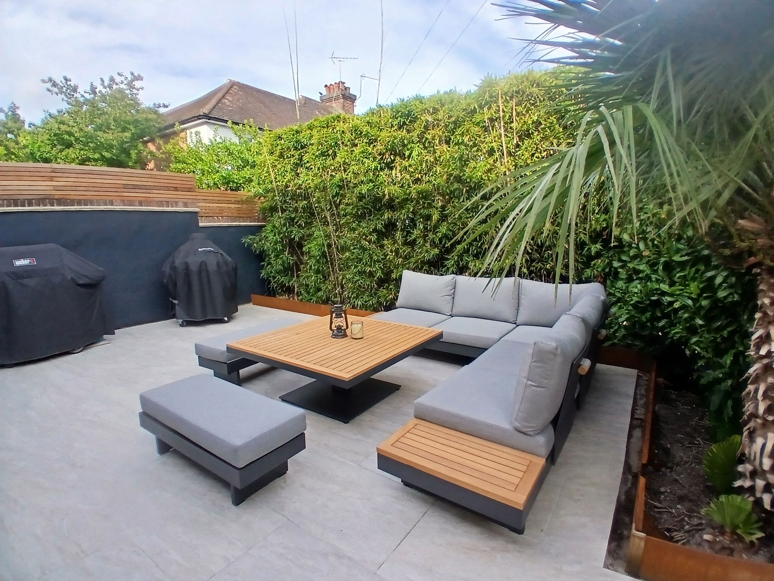 Contemporary courtyard garden featuring curved steel garden edging, architectural planting and modern paving.