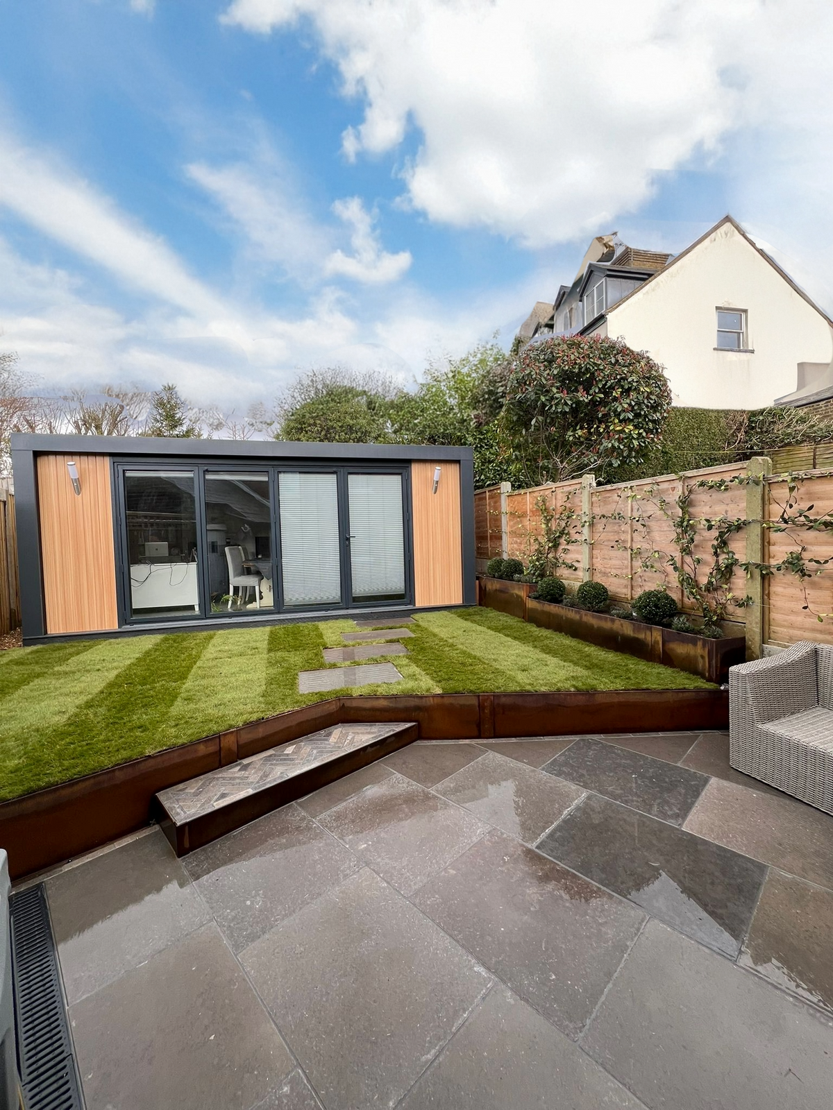 Contour Corten steel raised garden beds creating tiered planting in a contemporary landscaped garden