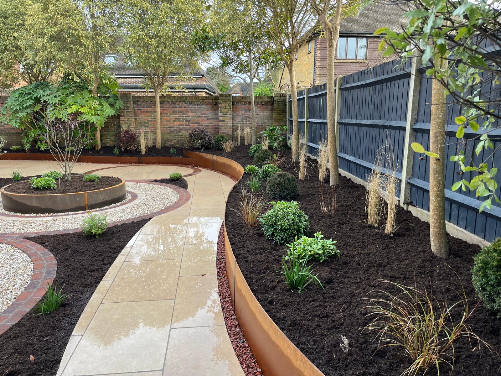 Corten Contour Raised Bed steel edging, used in 3 heights to create depth & levels in a garden. This has created curved planting borders, a clean edge around paving and walkways.