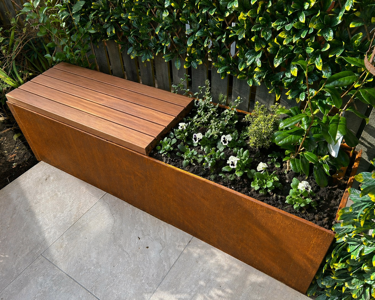 Modal integrated Bench GEO shown integrated in the Contour planter edge. Stand alone planter with seat topper.  This creates a seating area with in the planter. Corten Steel Garden Edging, creating boundary between soil, planting and gravel path. Lawn edge, garden border, flower beds, raised edging & planters. Metal, weathering steel, or powder coated steel with Douglas fir timber.  Garden walkway, path and paving edging, zoned seating area and boundaries